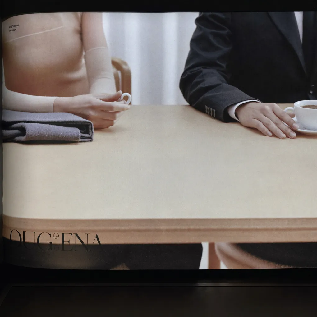 Zwei Personen an einem hellen Besprechungstisch, dazwischen Kaffeetassen und Unterlagen.